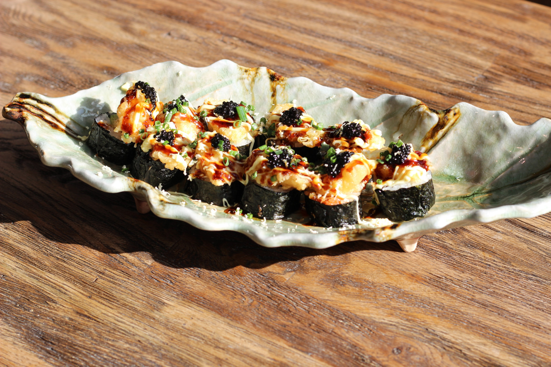 Friterad laxrull med tempura, lök och kaviar på keramikfat