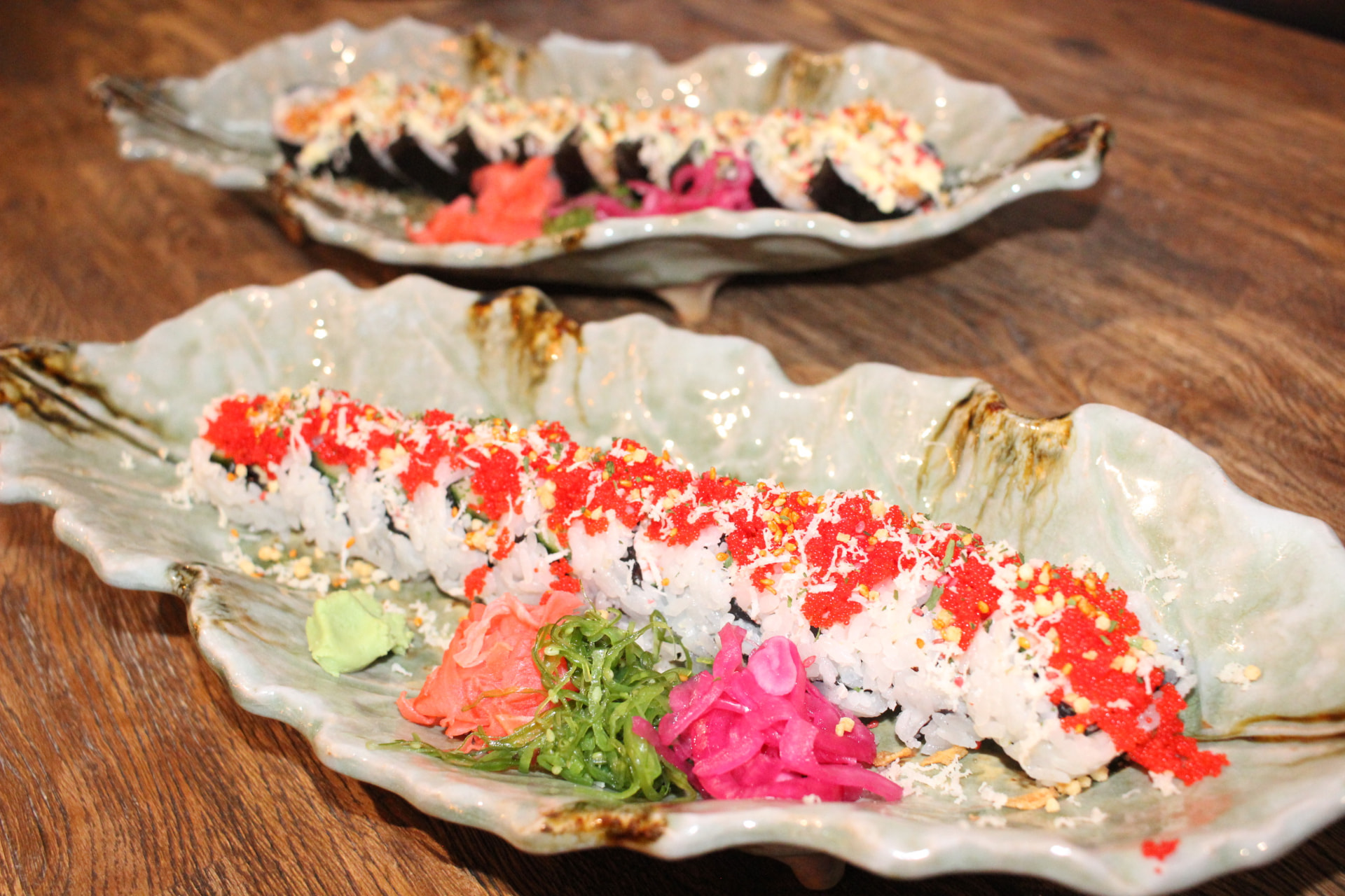 Makirullar med röd tobiko, ingefära och wakame på keramikfat